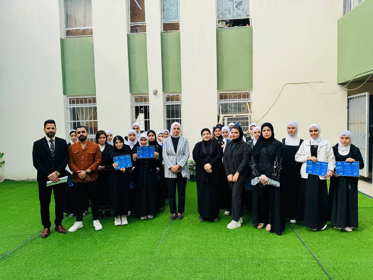 صورة جماعية لطالبات اعدادية بابل المهنية للبنات مع الكادر التدريسي في اروقة المدرسة